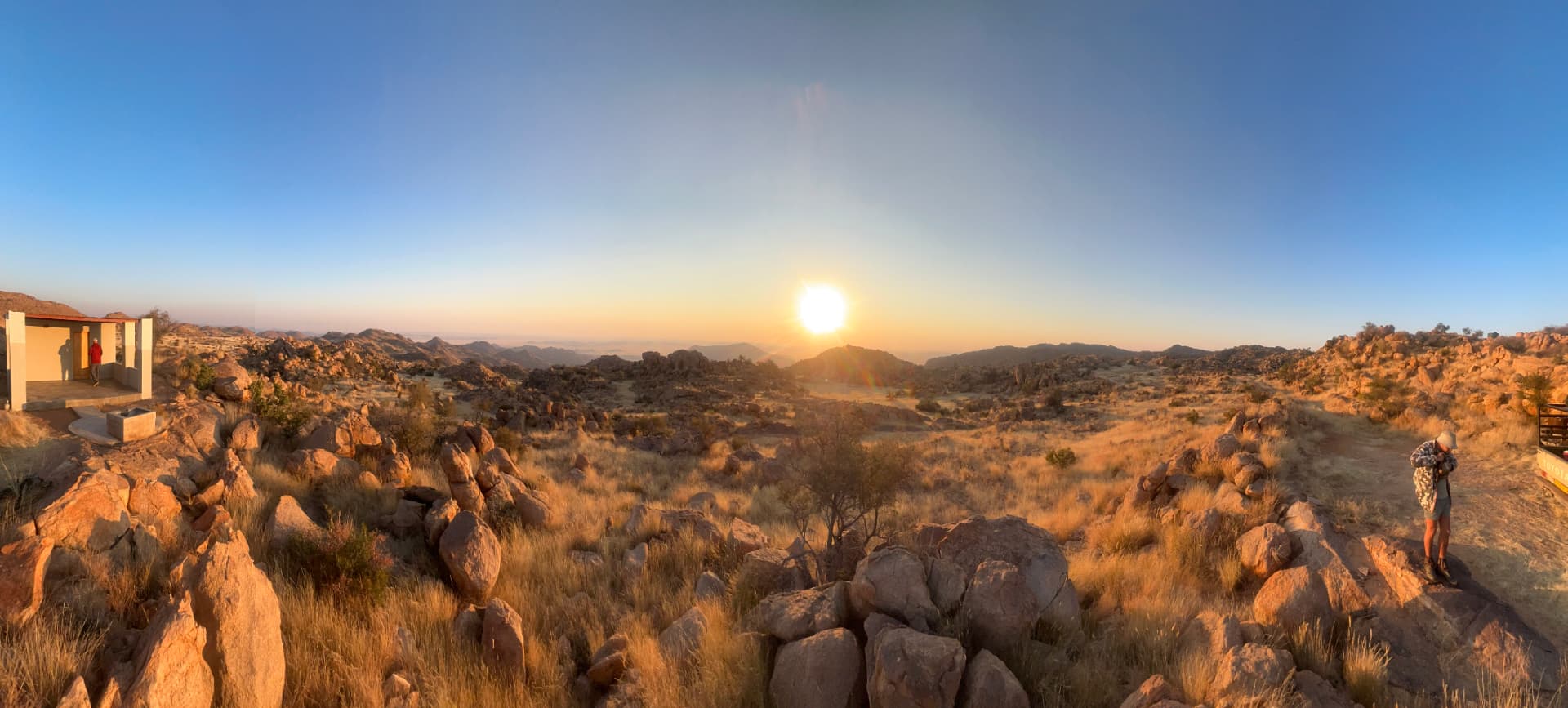 Panoramic sunrise light spilling across a rocky Namibian mountainside